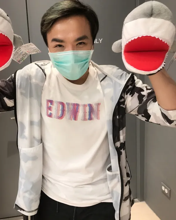 簡昭漢的 YouTube 頻道肖像：戴著口罩、雙手套著灰白鯊魚手偶，站在深色室內背景前