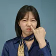 徐人崢所創作的 NiBO 官方角色頭像：短髮女性穿深藍上衣與金色領巾，在藍灰色背景前做出俏皮表情